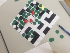 Foto eines quadratischen Spielbrettes mit schwarzen, weißen, grünen und roten Spielsteinen, "Game Design", ZIMD